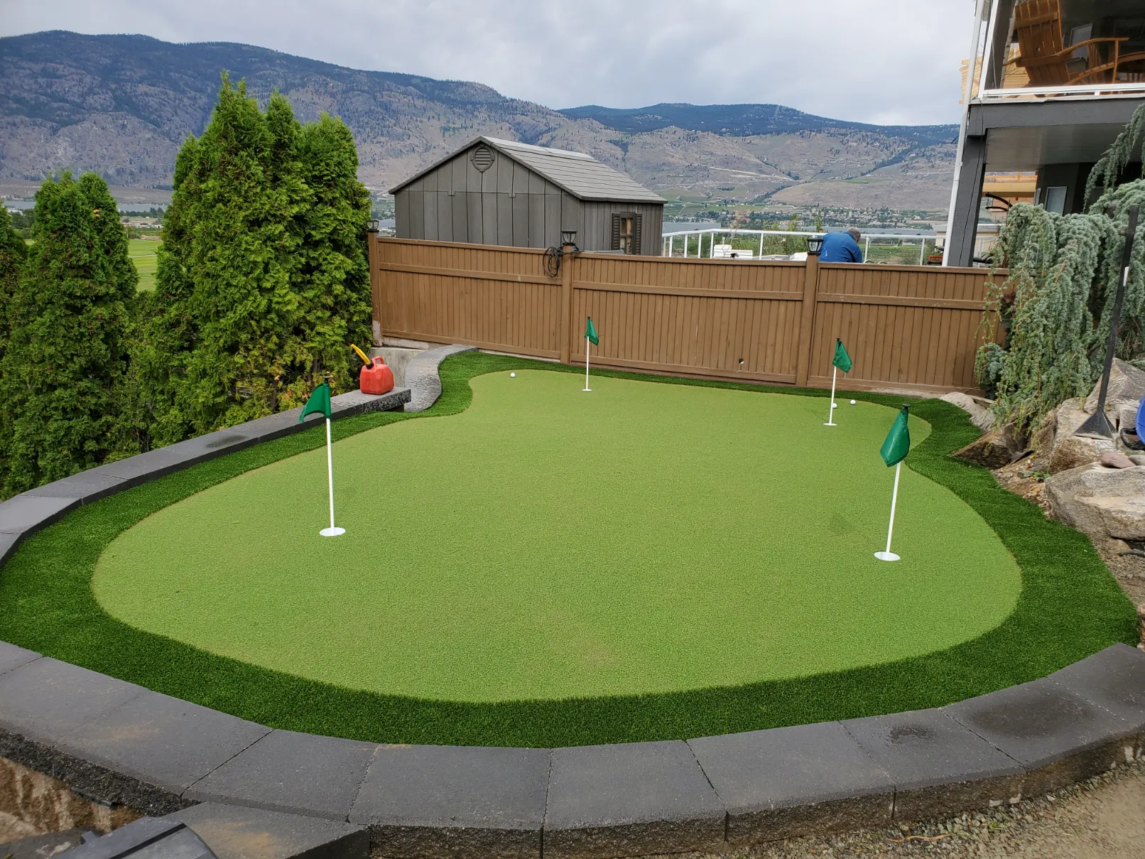 Professional backyard putting green installation with premium synthetic turf and regulation cup in Osoyoos BC