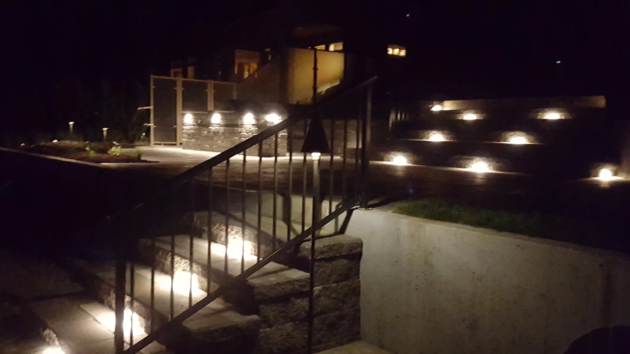 Professional landscape lighting with LED pathway fixtures illuminating garden walkway in Osoyoos BC