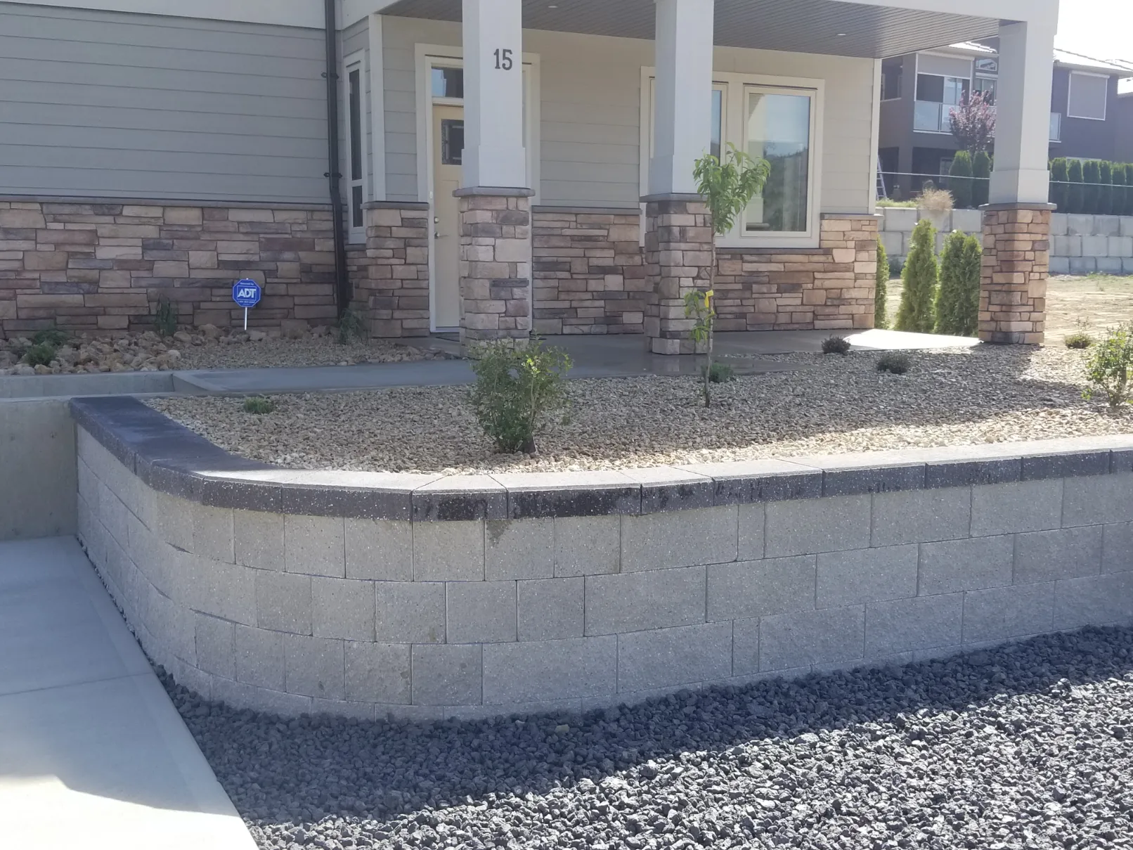 Premium decorative stone retaining wall with cap blocks and landscape lighting for Oliver residential project